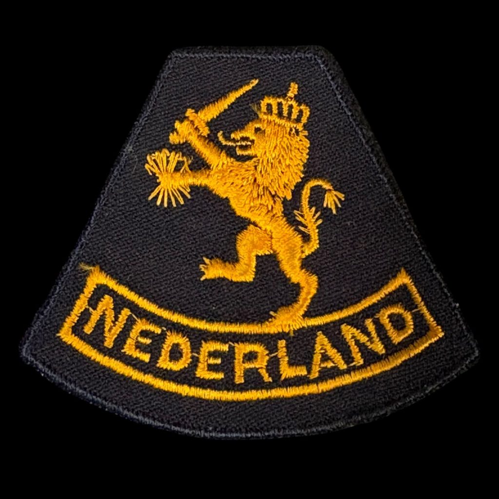 Mouwleeuw model 1940 Nederlandse aanmaak 1945 Brabants weefsel op zwarte ondergrond. Gedragen door het Vrouwen Hulp Korps en het Korps Gezagstroepen