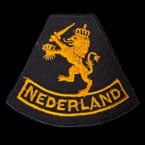 Mouwleeuw model 1940 Nederlandse aanmaak 1945 Brabants weefsel op zwarte ondergrond. Gedragen door het Vrouwen Hulp Korps en het Korps Gezagstroepen